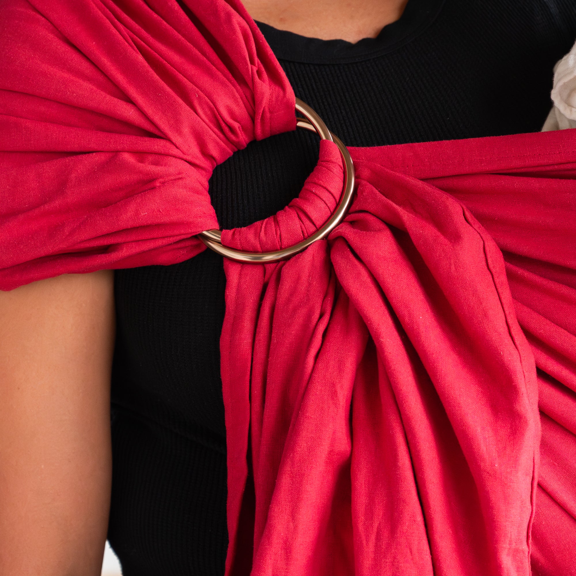 Red sling sling with a close up of the champagne rings against a black shirt