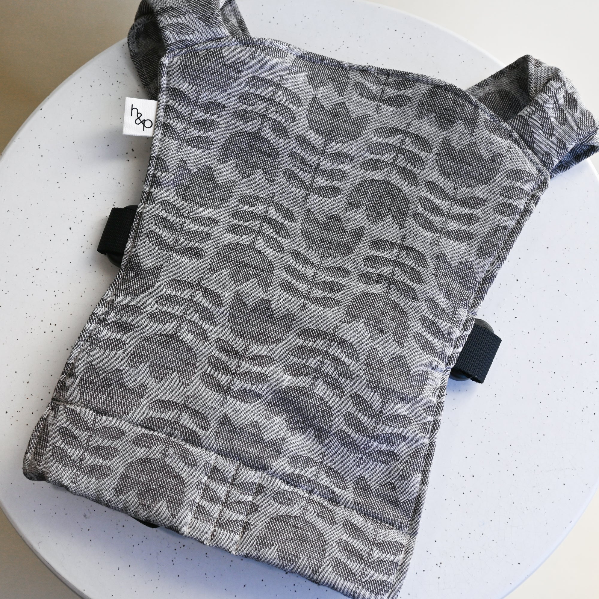 A grey woven tulip design on a doll carrier