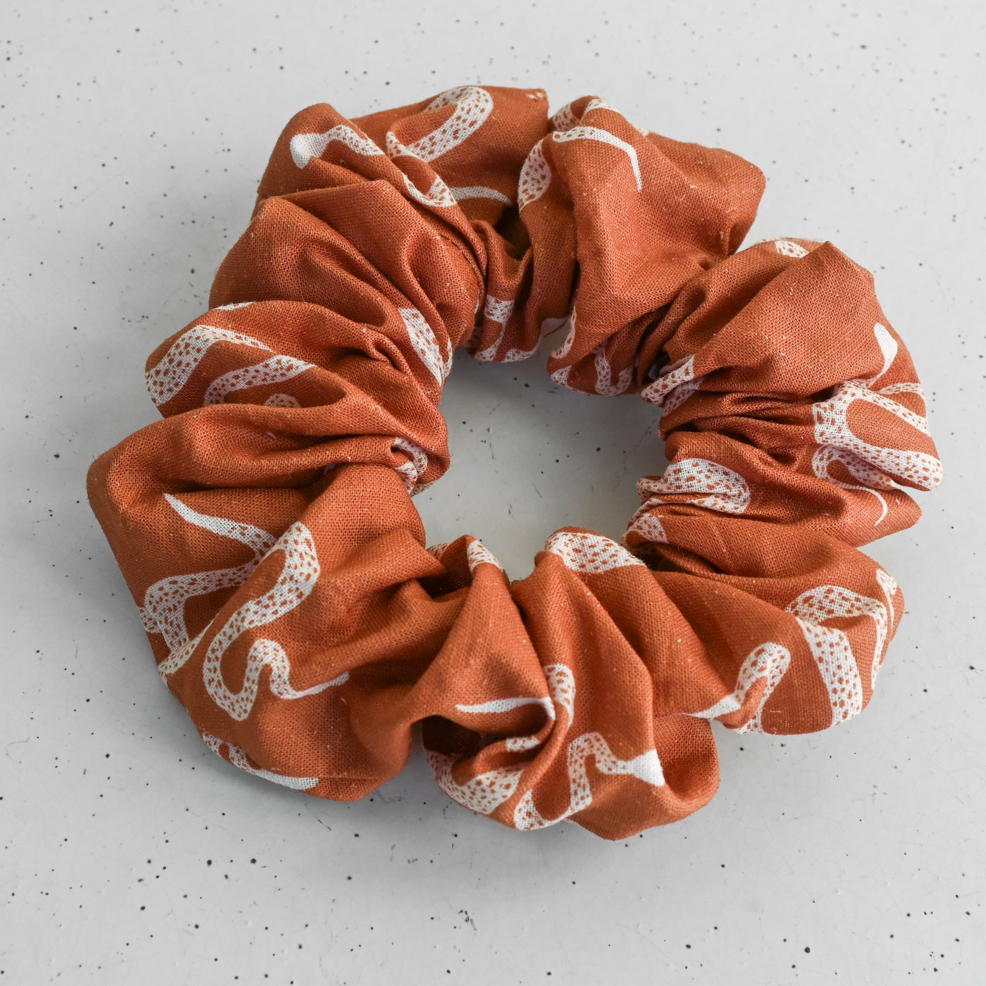rust scrunchie with snake pattern on a white background