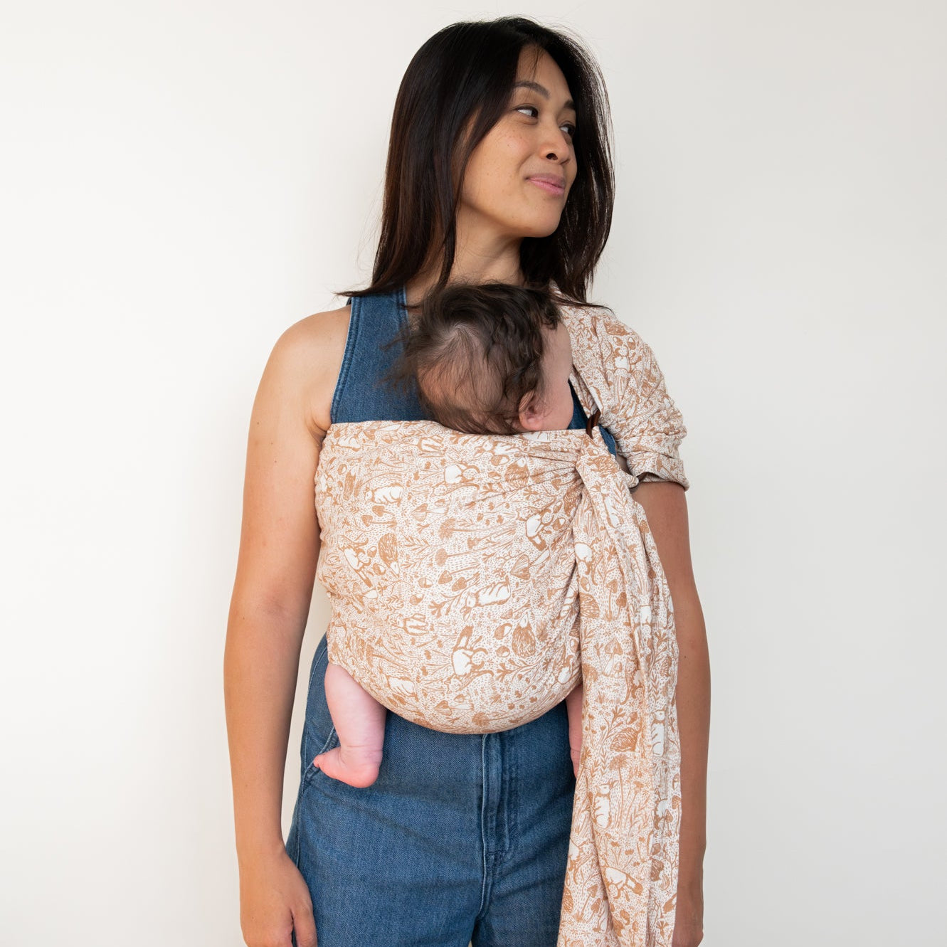 Woman wearing baby in woodland creature ring sling