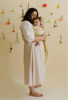 Woman wearing infant in sunflower ring sling baby carrier
