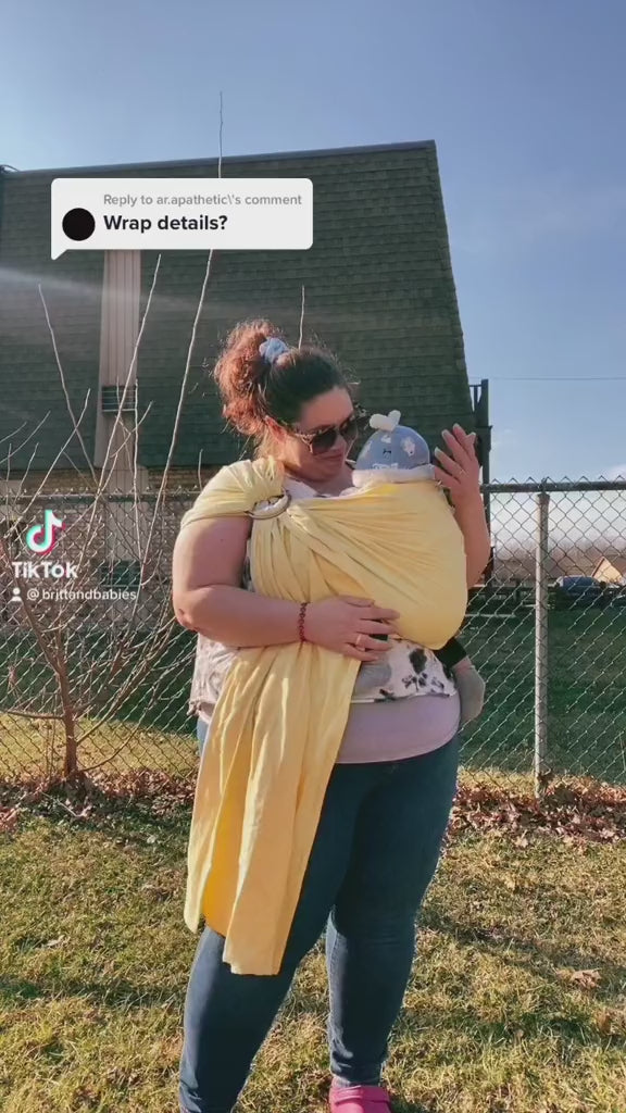 Plus size mother wearing her baby in a yellow ring sling plus size baby carrier