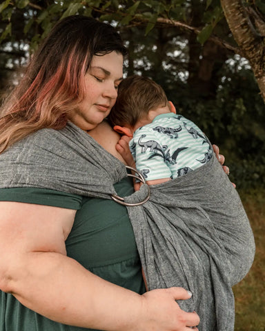 Mother wearing toddler in a ring sling