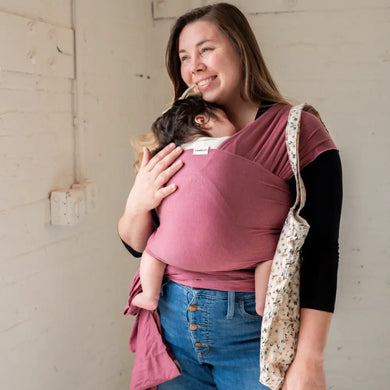 Mother wearing baby in pink stretchy baby wrap 