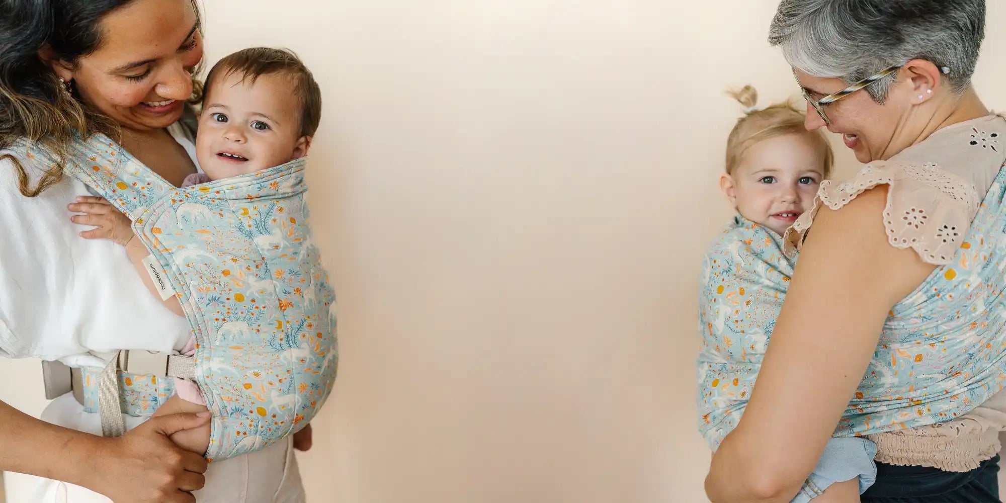 Two women carrying babies in patterned slings.